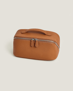 LayFlat Vanity Bag in brown full grain leather with zip-around closure and handle.