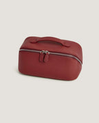 LayFlat Vanity Bag in red full grain leather with zip-around closure and handle.