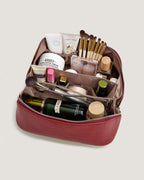 Interior view of a layflat leather vanity bag filled with beauty products and makeup tools.
