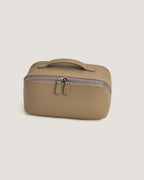 LayFlat leather vanity bag in a soft beige color with zip-around closure and handle.