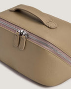 LayFlat Vanity Bag made of full grain leather, featuring a zip-around closure and handle for easy portability.
