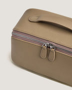 Close-up view of layflat leather vanity bag highlighting its zipper and textured leather surface.