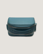 Stylish leather makeup bag in teal color with double zipper design and durable material for organization.