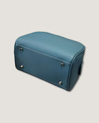 Leather makeup bag in blue color, showcasing a smooth texture and sturdy design for organization and durability.