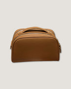 Stylish leather makeup bag in brown, designed with double zipper and spacious interior for organization.