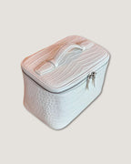Medium train case with Italian leather in white, featuring a top handle and zip-around closure.