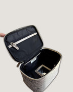 Interior view of a medium leather train case showing zippered pockets and spacious design.