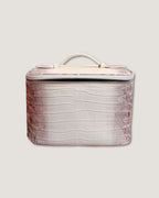 Medium leather train case in a stylish crocodile pattern with a zip closure and flat top handle.