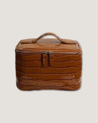 Medium Train Case in brown crocodile pattern leather with top handle and zip closure.