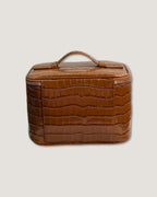 Medium Train Case in brown Italian leather with top handle and zip-around closure.