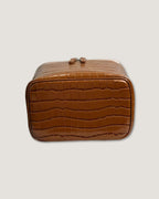 Medium Train Case in brown crocodile texture with a zip-around closure and sleek design.