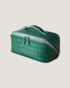layflat leather vanity bag in green crocodile pattern with silver zipper and top handle.