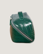 Layflat leather vanity bag showing a green crocodile print design and zip closure, ideal for makeup and toiletries.