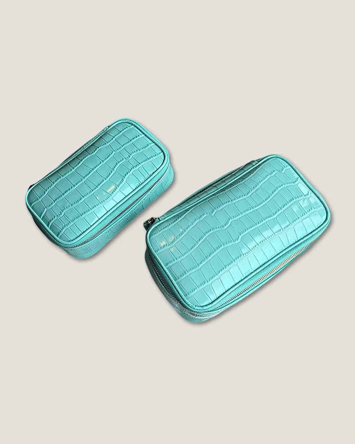 large rectangular makeup bag in crocodile patterned lake water blue, featuring two sizes and zippered closure.