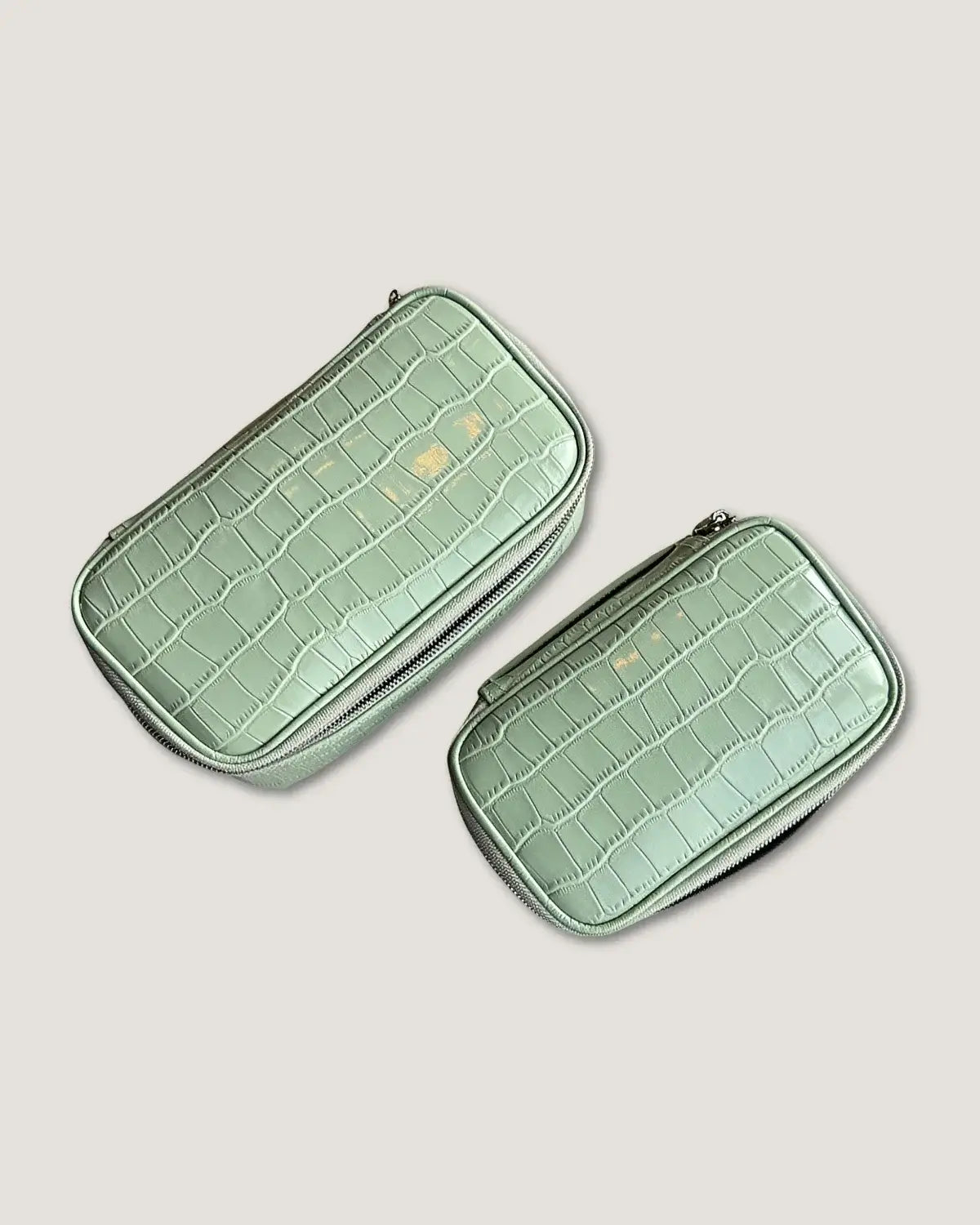 Large rectangular makeup bag in light green crocodile pattern, featuring zippered pockets and a water-resistant lining.