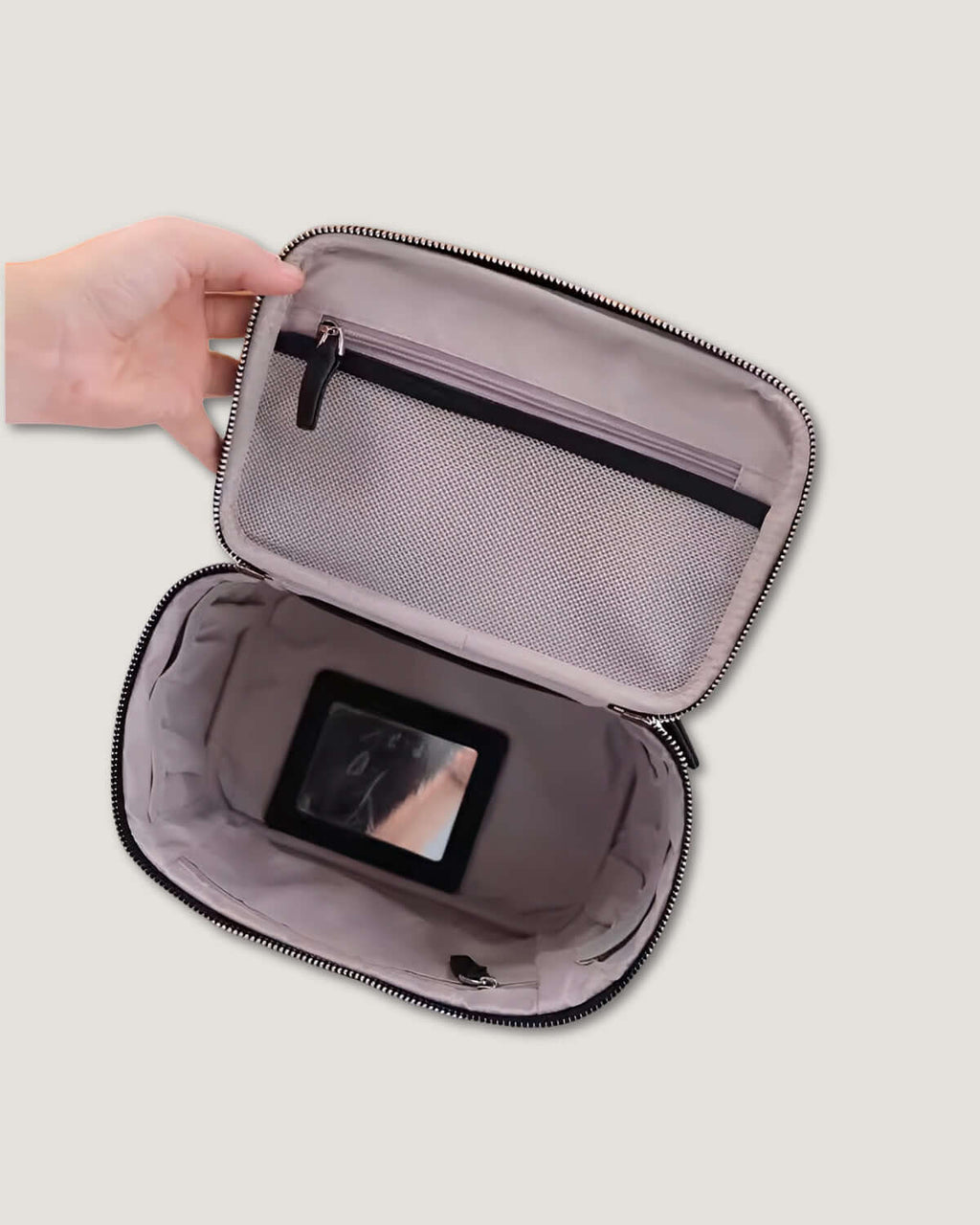 Inside view of a medium leather vanity bag showing open pockets and a small mirror.