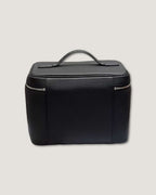 Medium leather vanity bag in black, designed for travel with zippered and open pockets, featuring a top handle.