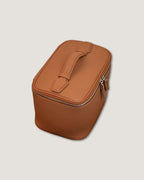 Medium leather vanity bag in tan color with zip-around closure and flat handle.