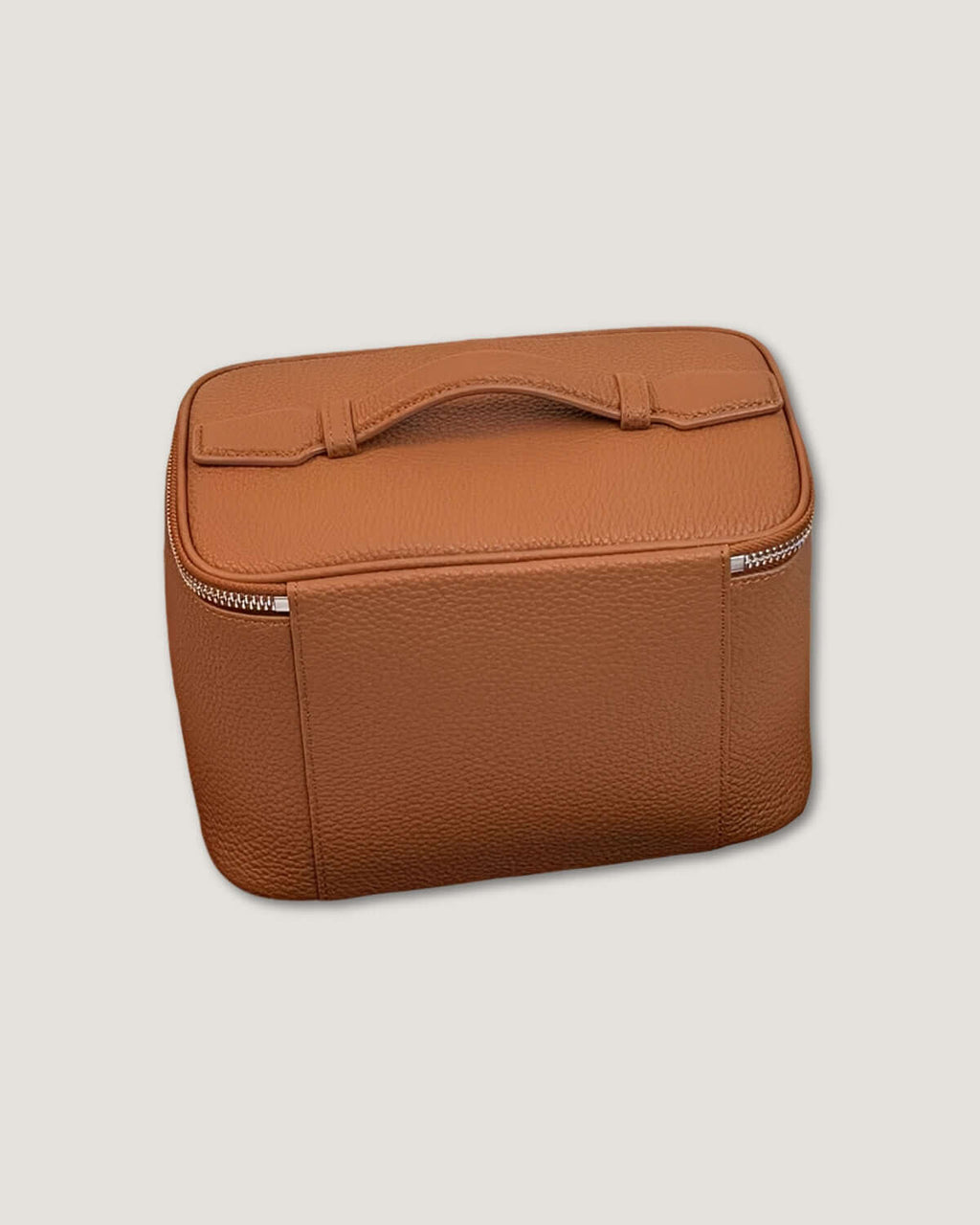 Medium leather vanity bag in tan full grain leather with top handle and zip-around closure.