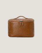 Luxury leather train case in brown, featuring zip-around closure and top handle for portability.