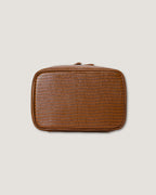 Stylish leather train case with a textured design, ideal for organizing beauty essentials while traveling.