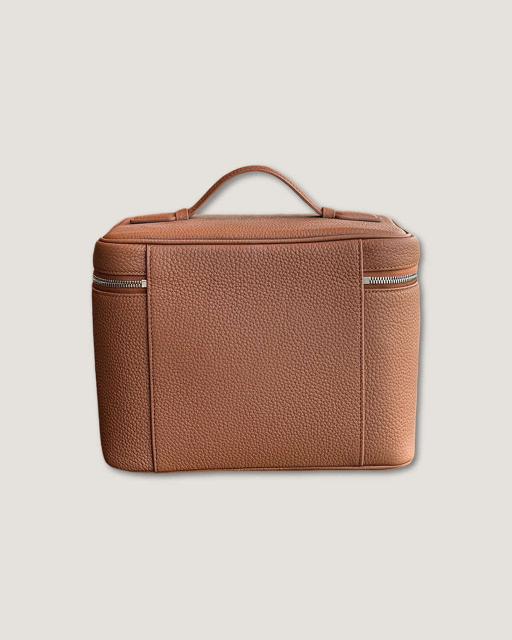 XL leather train case in full grain leather with metal zippers and top handle, suitable for organizing beauty products.