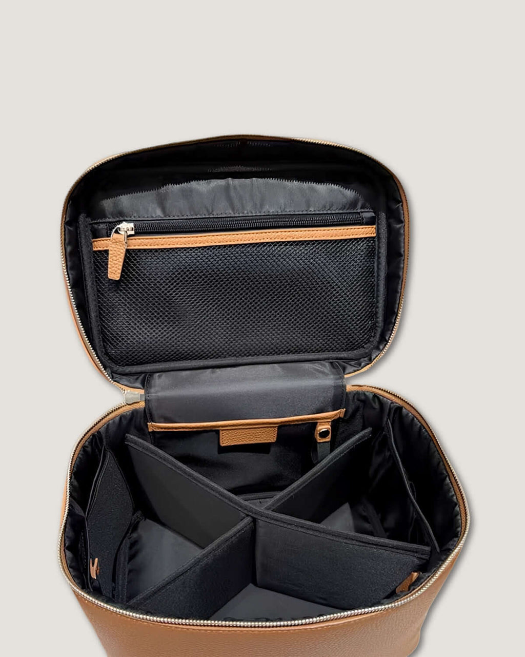 Interior view of XL leather train case featuring zippered and mesh pockets with adjustable dividers.